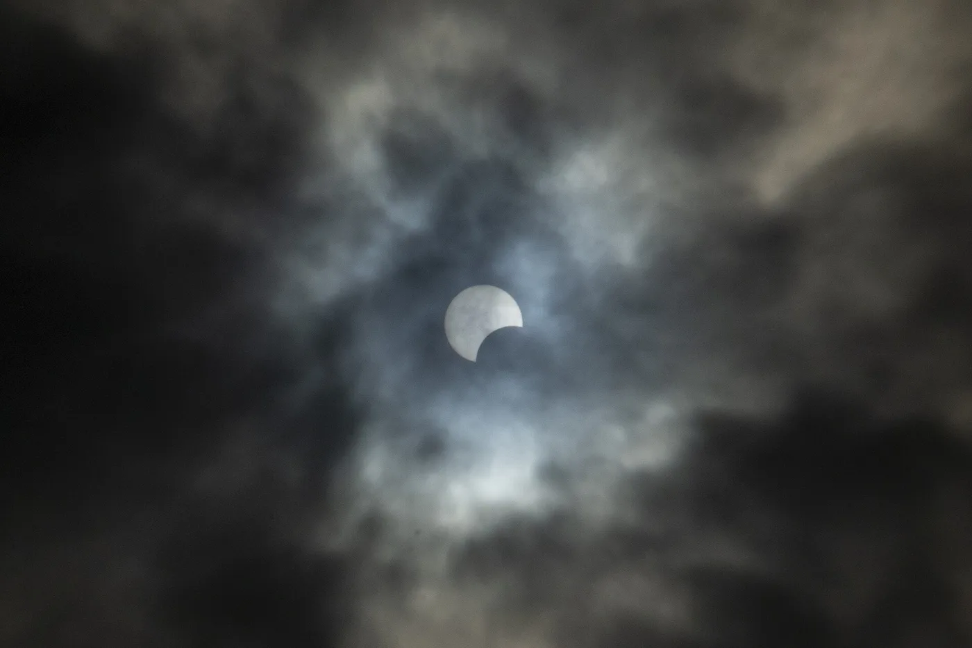 Fase parcial de un eclipse solar visto entre nubes